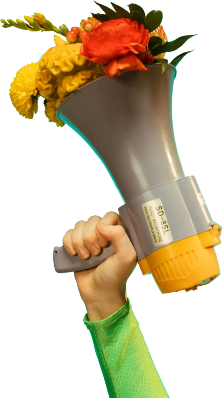 Mão segurando um megafone com flores coloridas saindo do alto-falante